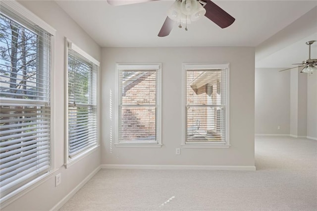 spare room with baseboards, ceiling fan, and light colored carpet