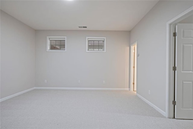 unfurnished room with visible vents, baseboards, and light carpet