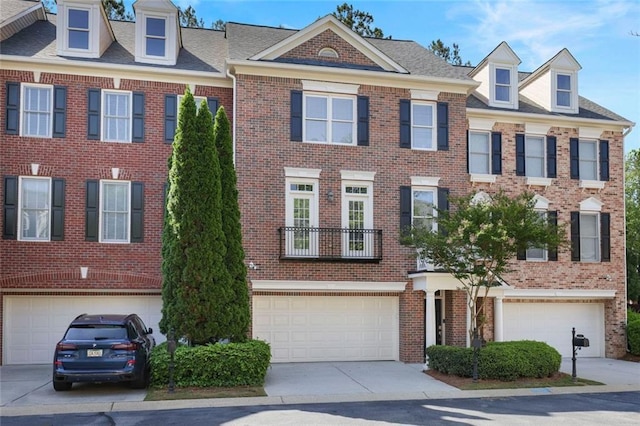 townhome / multi-family property with brick siding, a garage, roof with shingles, and driveway