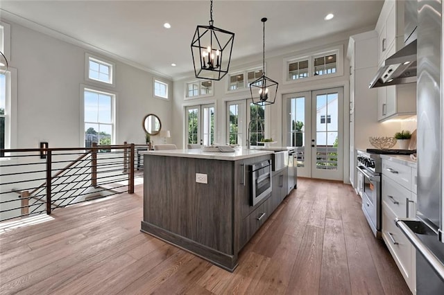 kitchen featuring white cabinets, a center island, stainless steel appliances, and french doors