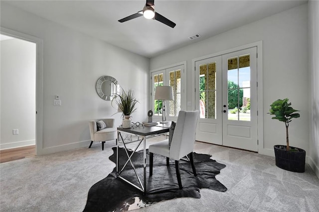 carpeted dining area with ceiling fan and french doors