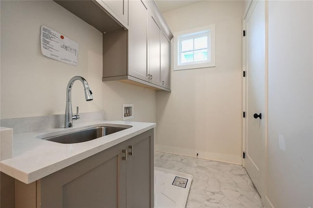 laundry area with sink, hookup for a washing machine, and cabinets