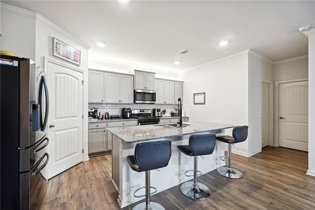 6004 Screech Owl Dr, Flowery Branch, GA 30542 - kitchen with appliances with stainless steel finishes, a sink, dark wood-style flooring, a kitchen breakfast bar, and ornamental molding
