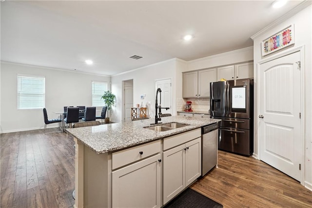 6004 Screech Owl Dr, Flowery Branch, GA 30542 - kitchen with stainless steel appliances, a sink, ornamental molding, dark wood finished floors, and light stone countertops