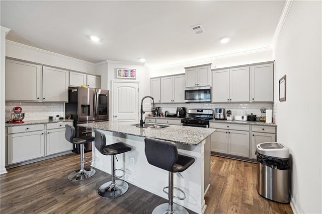 6004 Screech Owl Dr, Flowery Branch, GA 30542 - kitchen featuring appliances with stainless steel finishes, a sink, tasteful backsplash, a breakfast bar, and crown molding