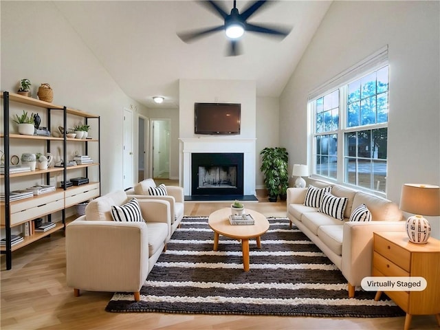 living room featuring hardwood / wood-style flooring, vaulted ceiling, and ceiling fan