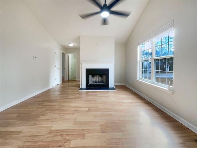 unfurnished living room with ceiling fan, vaulted ceiling, and light wood-type flooring