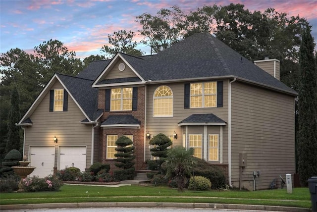 view of front of house featuring a garage and a yard