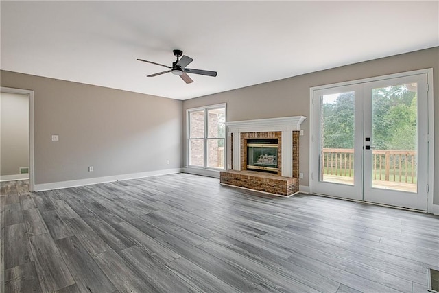 19 Quimby Jackson Rd, Newnan, GA 30263 - unfurnished living room with french doors, a ceiling fan, wood finished floors, and a brick fireplace