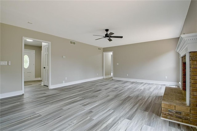 19 Quimby Jackson Rd, Newnan, GA 30263 - unfurnished living room with a ceiling fan, light wood-type flooring, and a brick fireplace