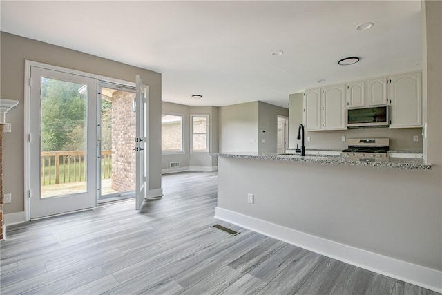 19 Quimby Jackson Rd, Newnan, GA 30263 - kitchen with stainless steel appliances, white cabinets, plenty of natural light, light wood-style floors, and recessed lighting