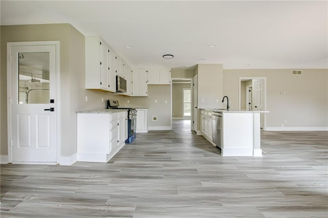 19 Quimby Jackson Rd, Newnan, GA 30263 - kitchen featuring appliances with stainless steel finishes, white cabinets, light wood-style flooring, and recessed lighting