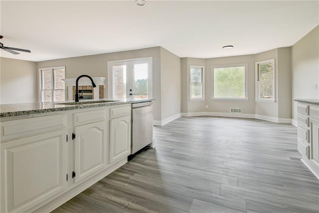 19 Quimby Jackson Rd, Newnan, GA 30263 - kitchen featuring stainless steel dishwasher, ceiling fan, light wood-type flooring, a fireplace, and white cabinets