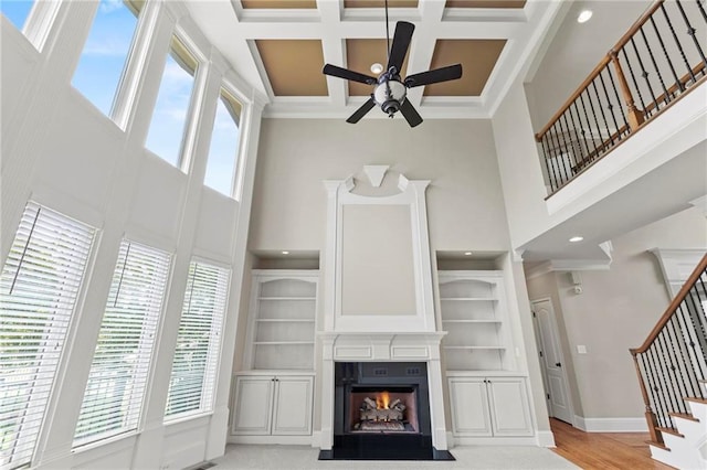 2602 Alcovy Club Dr, Dacula, GA 30019 - unfurnished living room featuring a towering ceiling, ceiling fan, stairs, a fireplace with flush hearth, and beamed ceiling