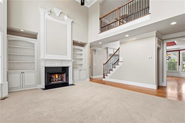 2602 Alcovy Club Dr, Dacula, GA 30019 - unfurnished living room featuring carpet, a fireplace with flush hearth, stairs, built in features, and recessed lighting