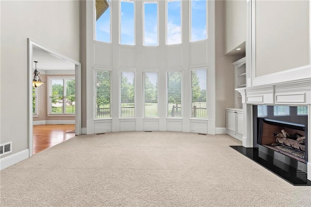 2602 Alcovy Club Dr, Dacula, GA 30019 - unfurnished living room with carpet floors, a towering ceiling, and a fireplace with flush hearth