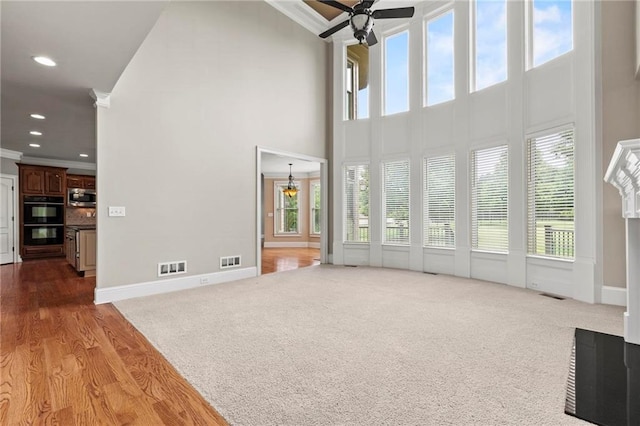 2602 Alcovy Club Dr, Dacula, GA 30019 - unfurnished living room featuring crown molding, a ceiling fan, a towering ceiling, carpet, and recessed lighting