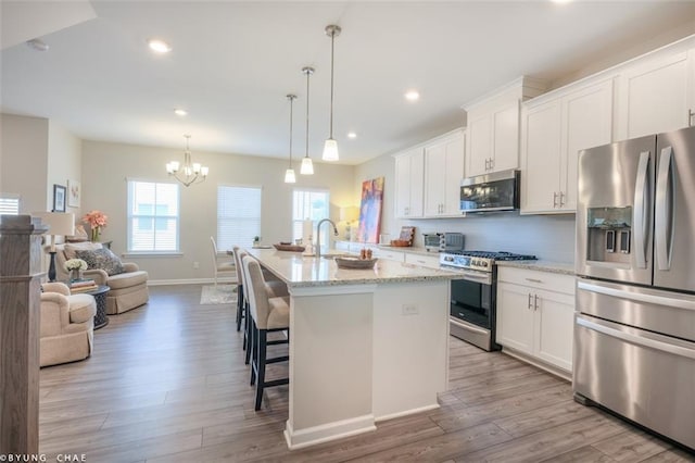 2247 Pink Hawthorn Dr, Buford, GA 30518 - kitchen featuring stainless steel appliances, wood finished floors, white cabinetry, and recessed lighting