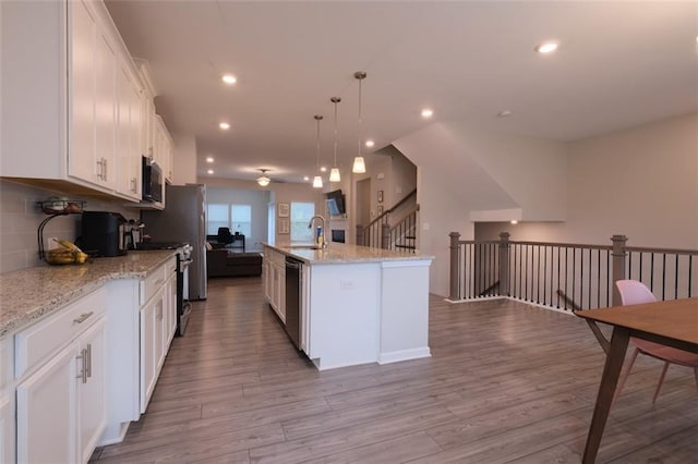 2247 Pink Hawthorn Dr, Buford, GA 30518 - kitchen with stove, white cabinetry, an island with sink, wood finished floors, and recessed lighting