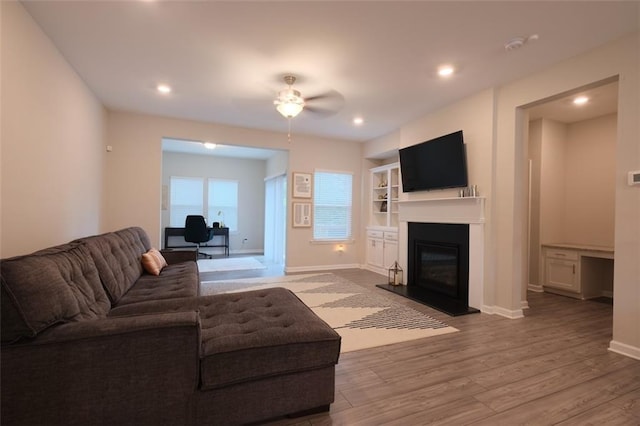 2247 Pink Hawthorn Dr, Buford, GA 30518 - living room with a glass covered fireplace, wood finished floors, a ceiling fan, an office area, and recessed lighting