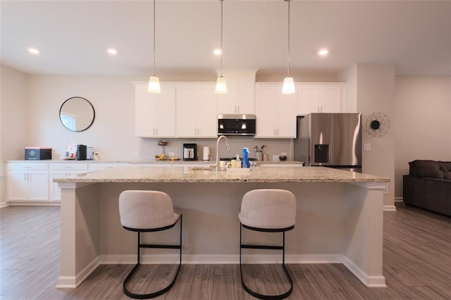 2247 Pink Hawthorn Dr, Buford, GA 30518 - kitchen featuring appliances with stainless steel finishes, a center island with sink, a kitchen breakfast bar, white cabinets, and recessed lighting