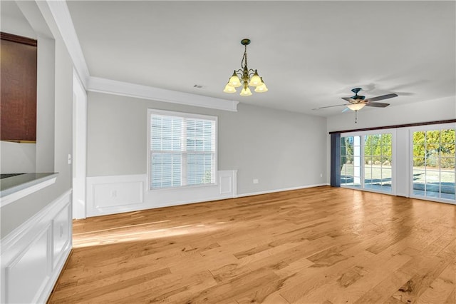 empty room featuring ceiling fan with notable chandelier and light hardwood / wood-style floors