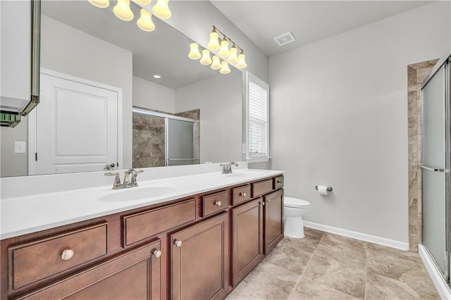 bathroom with vanity, a shower with shower door, and toilet