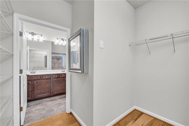 walk in closet featuring sink and light hardwood / wood-style flooring