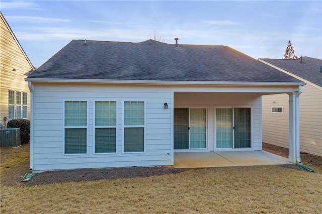 rear view of property with cooling unit, a lawn, and a patio area