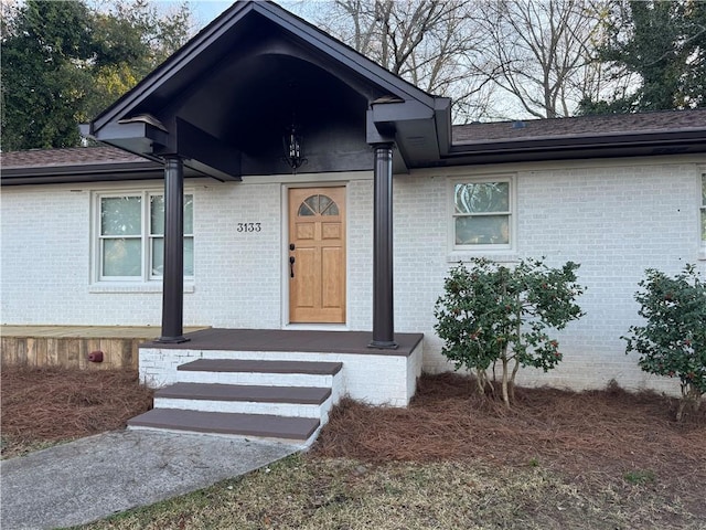 doorway to property featuring brick siding