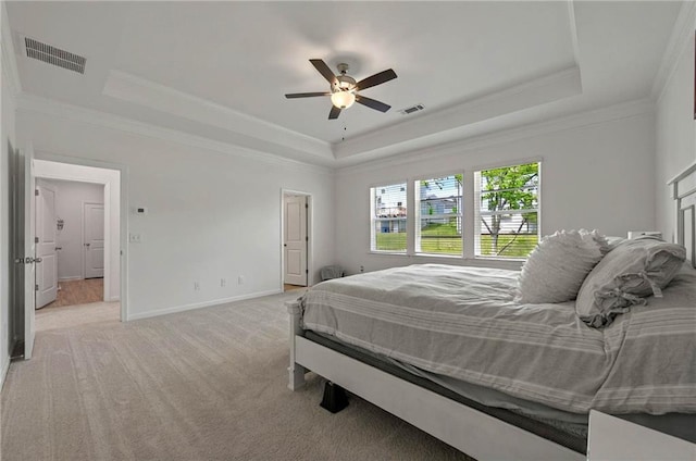 bedroom featuring a raised ceiling, carpet, crown molding, baseboards, and a ceiling fan