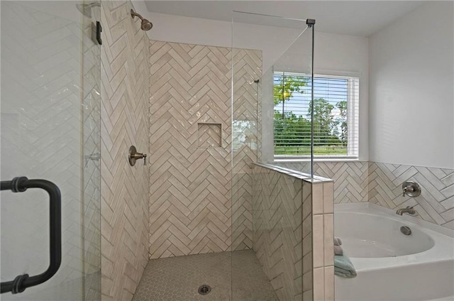 bathroom with a stall shower and a garden tub
