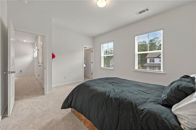 bedroom with light colored carpet and baseboards