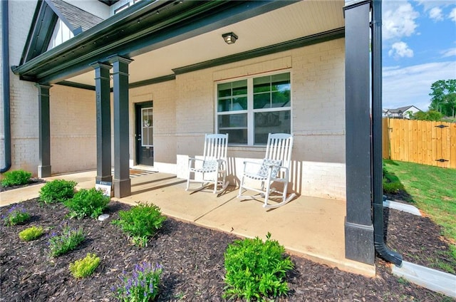 view of patio / terrace with a porch and fence