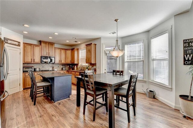 dining area featuring light wood-type flooring and sink