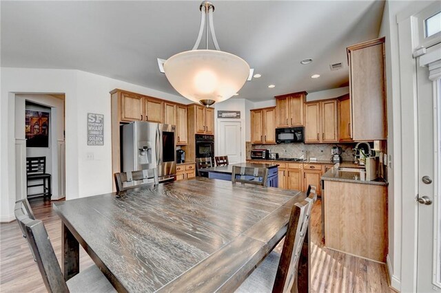 dining room with light wood-type flooring and sink