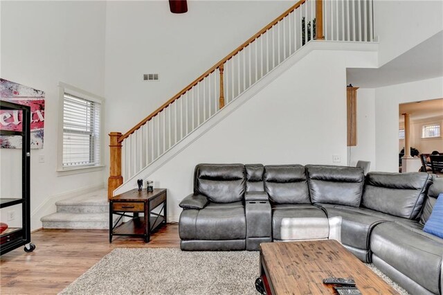 living room with light wood-type flooring and a high ceiling