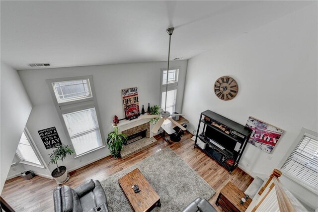 living room with hardwood / wood-style floors, a fireplace, and high vaulted ceiling