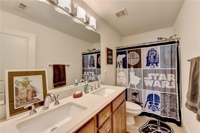 bathroom featuring vanity, curtained shower, and toilet