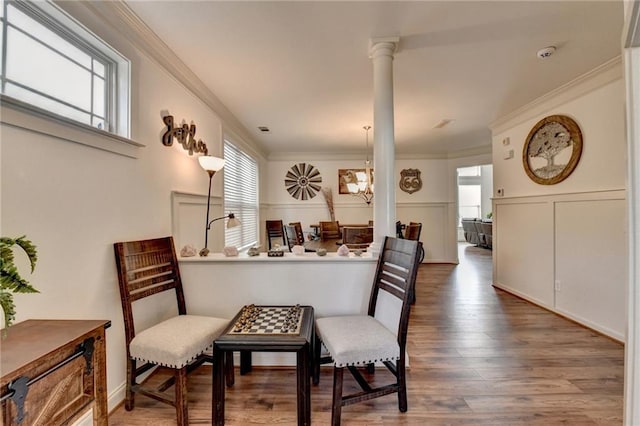 interior space with wood-type flooring, ornate columns, and ornamental molding