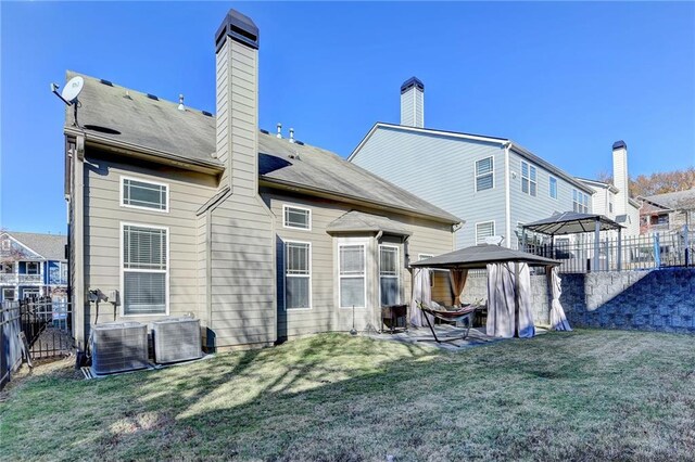 back of property featuring a gazebo, a yard, and cooling unit