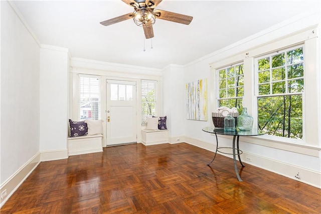 entryway with crown molding, baseboards, a wealth of natural light, and ceiling fan