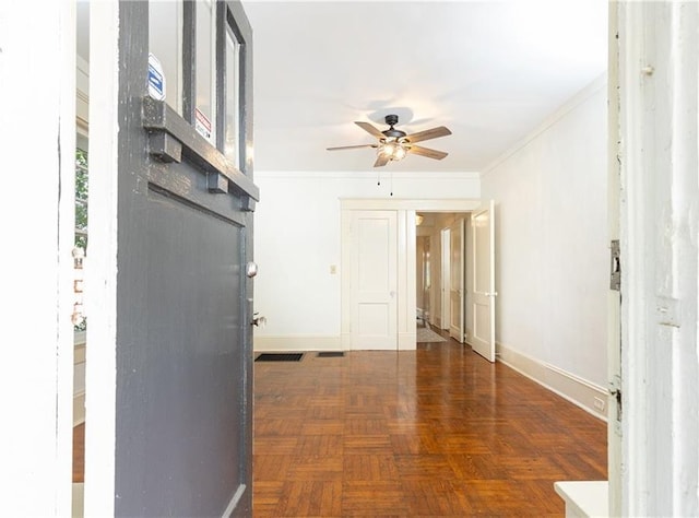 interior space featuring a ceiling fan, baseboards, and ornamental molding