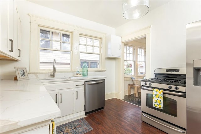 kitchen with a healthy amount of sunlight, white cabinets, stainless steel appliances, and a sink