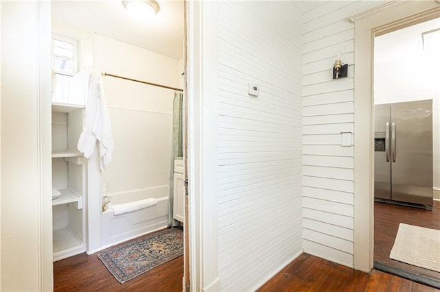 bathroom with a shower, a bathing tub, wood finished floors, and wood walls