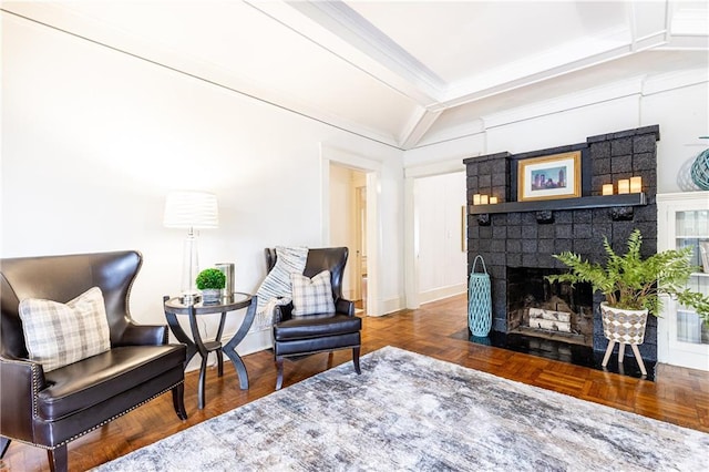 sitting room featuring a brick fireplace, lofted ceiling with beams, baseboards, and crown molding