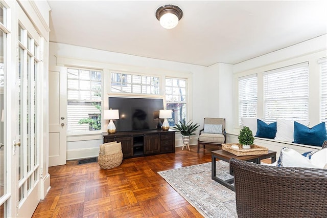 living room with a wealth of natural light, visible vents, and baseboards