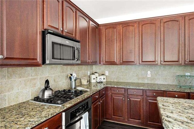 316 Branch Valley Dr NE, Dallas, GA 30132 - kitchen featuring appliances with stainless steel finishes, light stone countertops, and backsplash