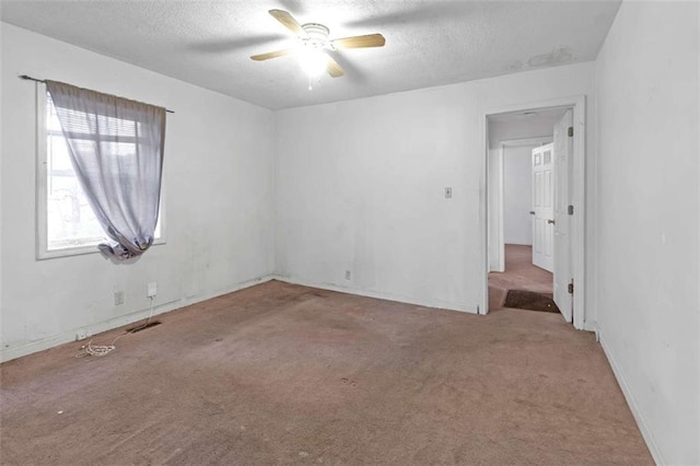 carpeted empty room featuring ceiling fan and a textured ceiling