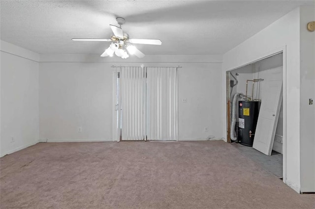 carpeted spare room with water heater and ceiling fan